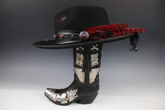 Black cowboy hat and boot with decorative elements on a gray background