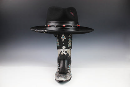 Black cowboy hat with decorative elements on a gray background