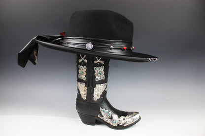 Black cowboy hat with decorative elements on a gray background