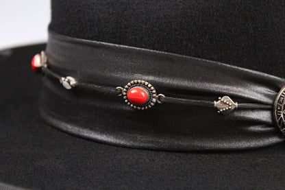 Black hat with decorative band featuring red stone and silver elements