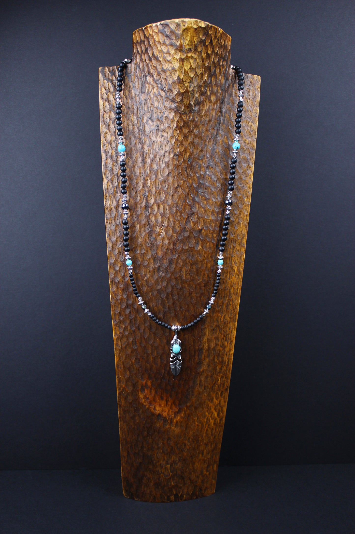 The Blue Wing Necklace, Detailed with hematite, howlite, black wood beads and silver beading, all of this leading to a very cool feather pendant.