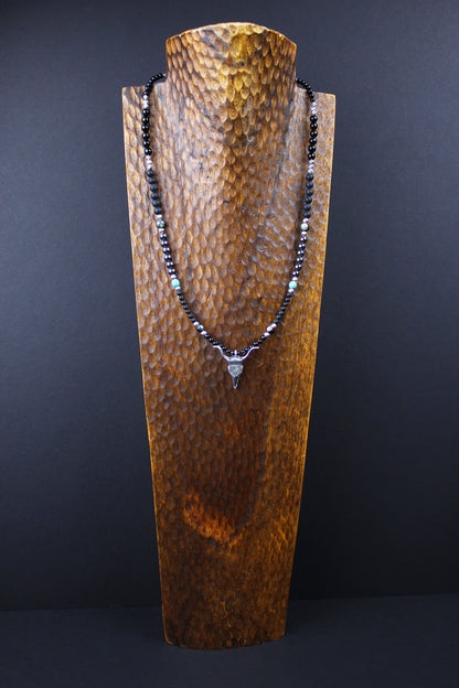 The Buffalo Smoke Necklace. Detailed with hematite, howlite, matte agate and silver beading, all of this leading to a very cool ram's head pendant.