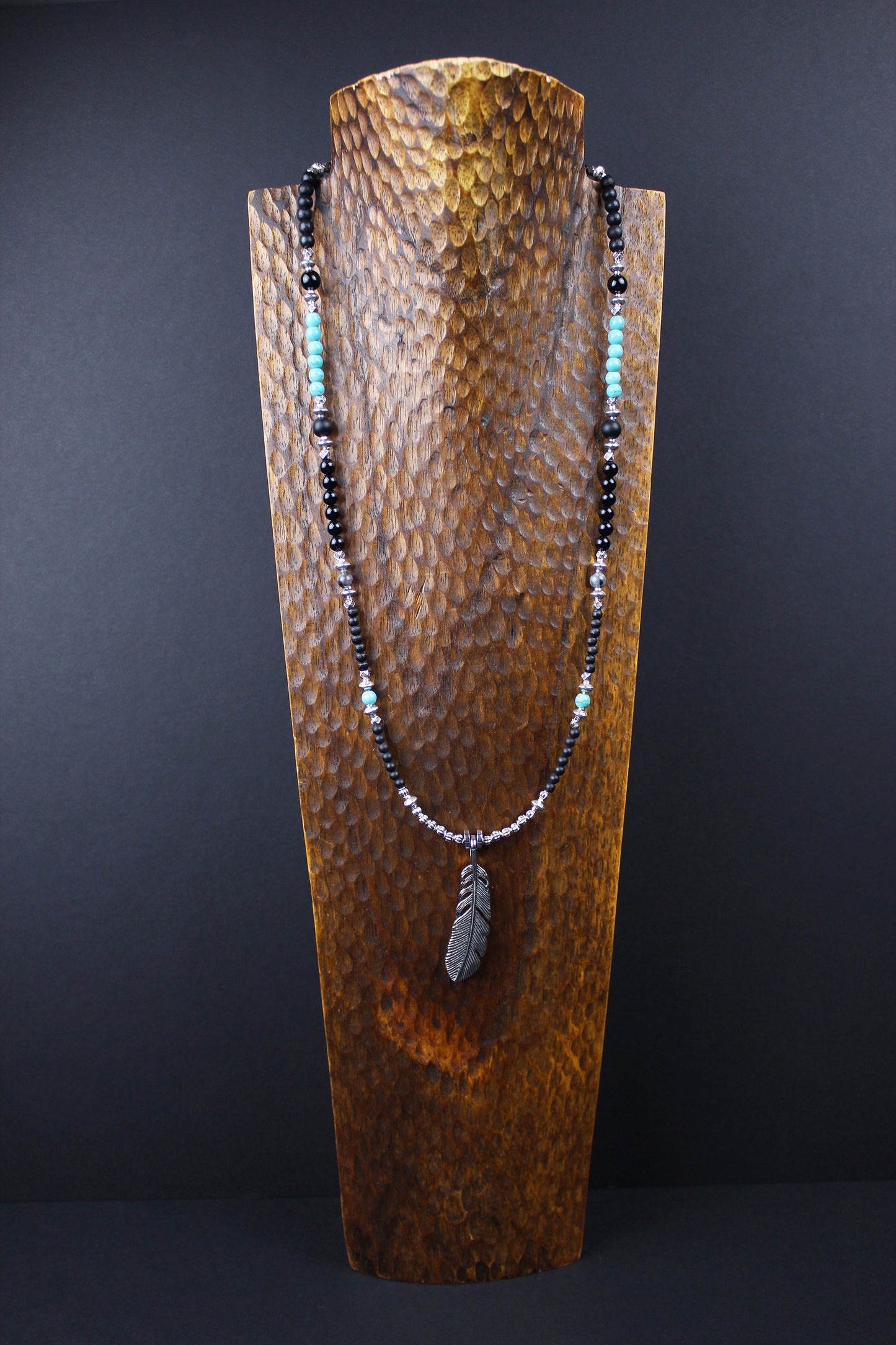 The Little Wing Necklace. Detailed with hematite, howlite, black wood beads and silver beading, all of this leading to a very cool feather pendant.