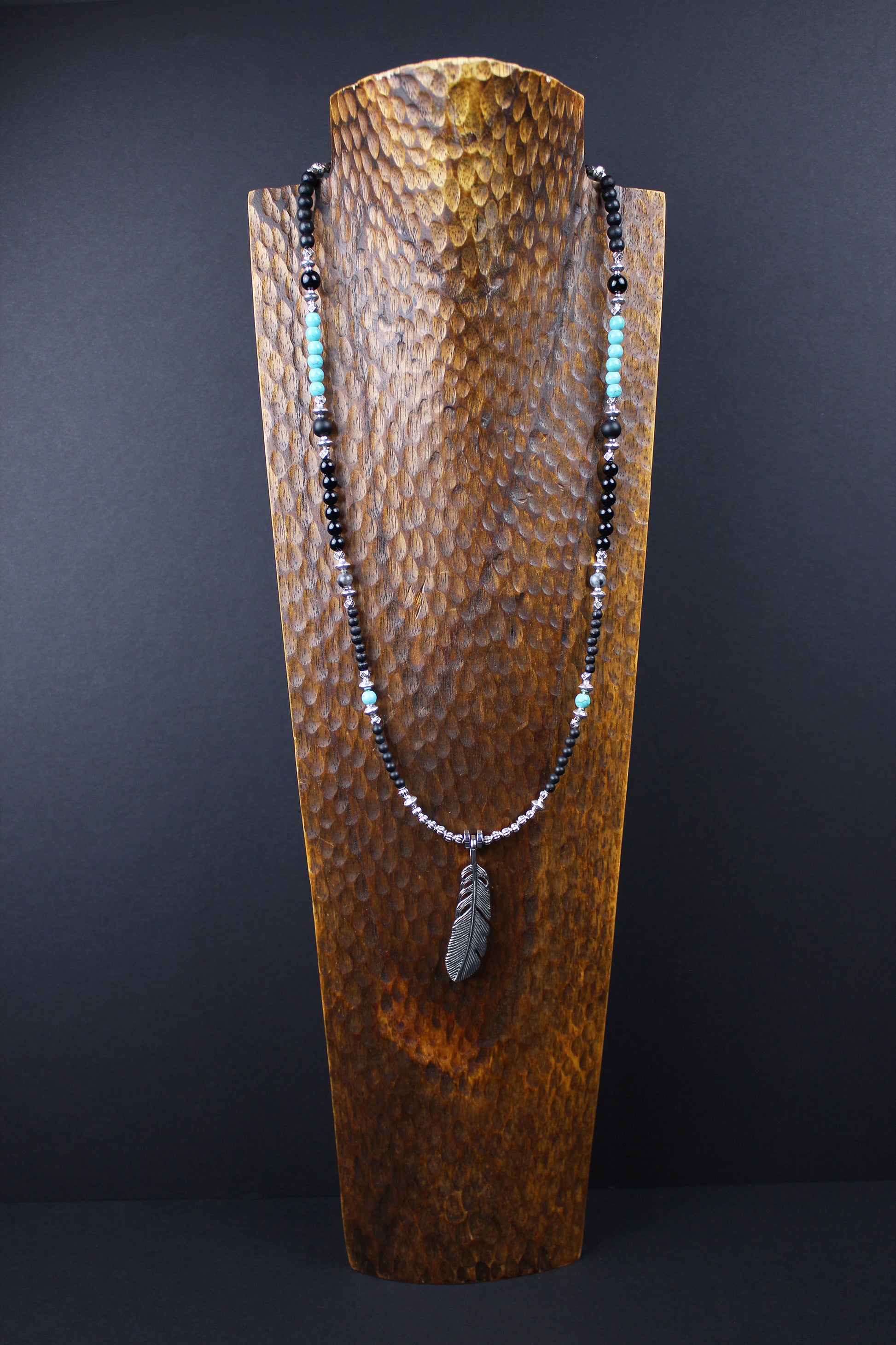 The Little Wing Necklace. Detailed with hematite, howlite, black wood beads and silver beading, all of this leading to a very cool feather pendant.