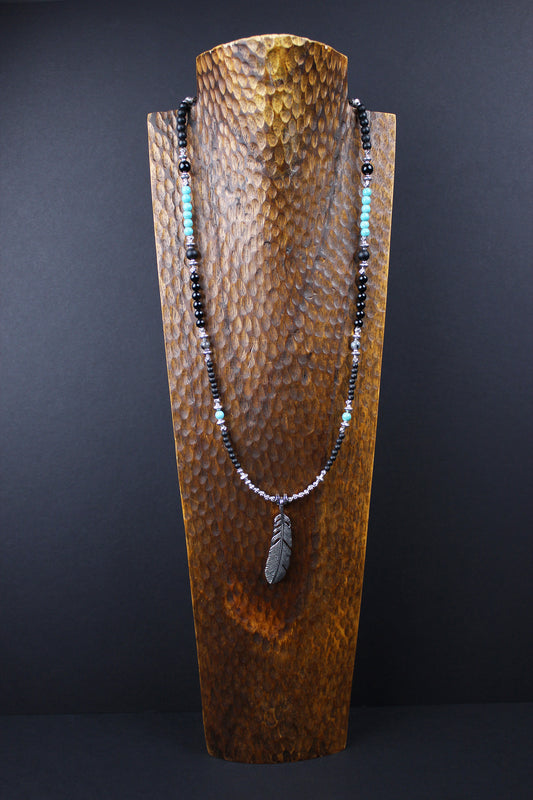 The Little Wing Necklace. Detailed with hematite, howlite, black wood beads and silver beading, all of this leading to a very cool feather pendant.
