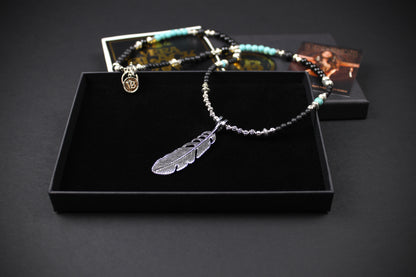 The Little Wing Necklace. Detailed with hematite, howlite, black wood beads and silver beading, all of this leading to a very cool feather pendant.