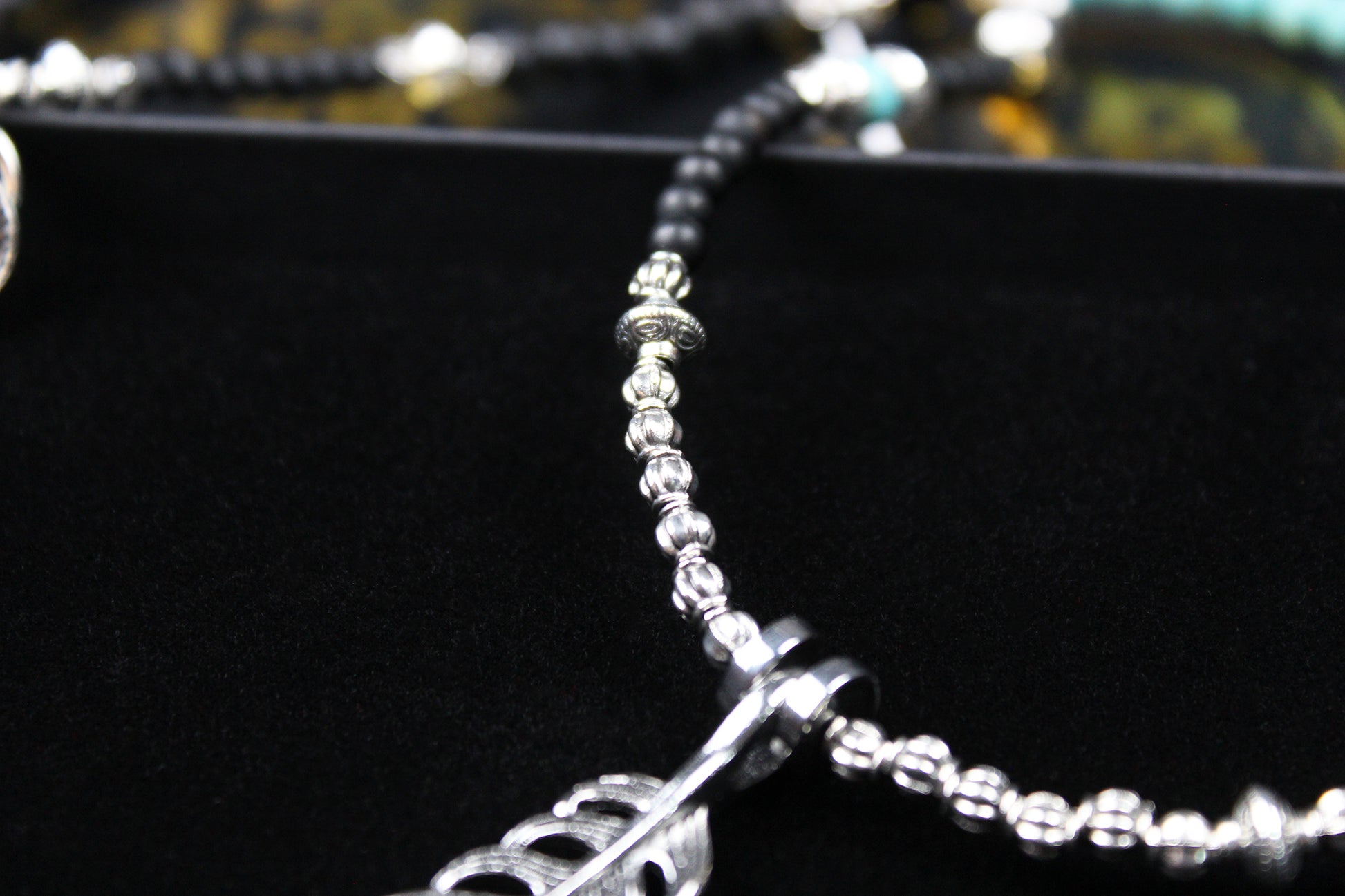 The Little Wing Necklace. Detailed with hematite, howlite, black wood beads and silver beading, all of this leading to a very cool feather pendant.
