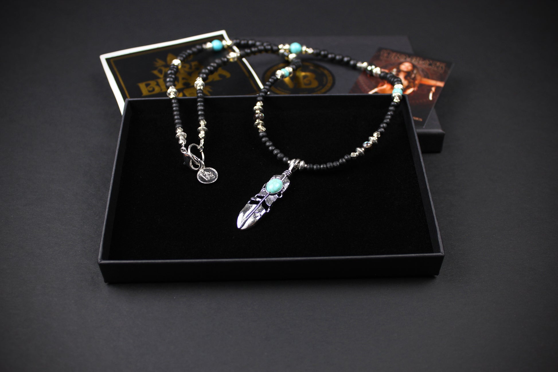 The Blue Wing Necklace, Detailed with hematite, howlite, black wood beads and silver beading, all of this leading to a very cool feather pendant.