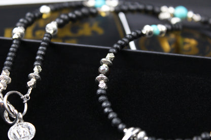 The Blue Wing Necklace, Detailed with hematite, howlite, black wood beads and silver beading, all of this leading to a very cool feather pendant.
