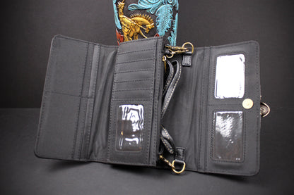 An open black nylon crossbody wallet with multiple card slots, clear ID windows, a detachable strap, and gold-tone hardware, photographed against a dark background.