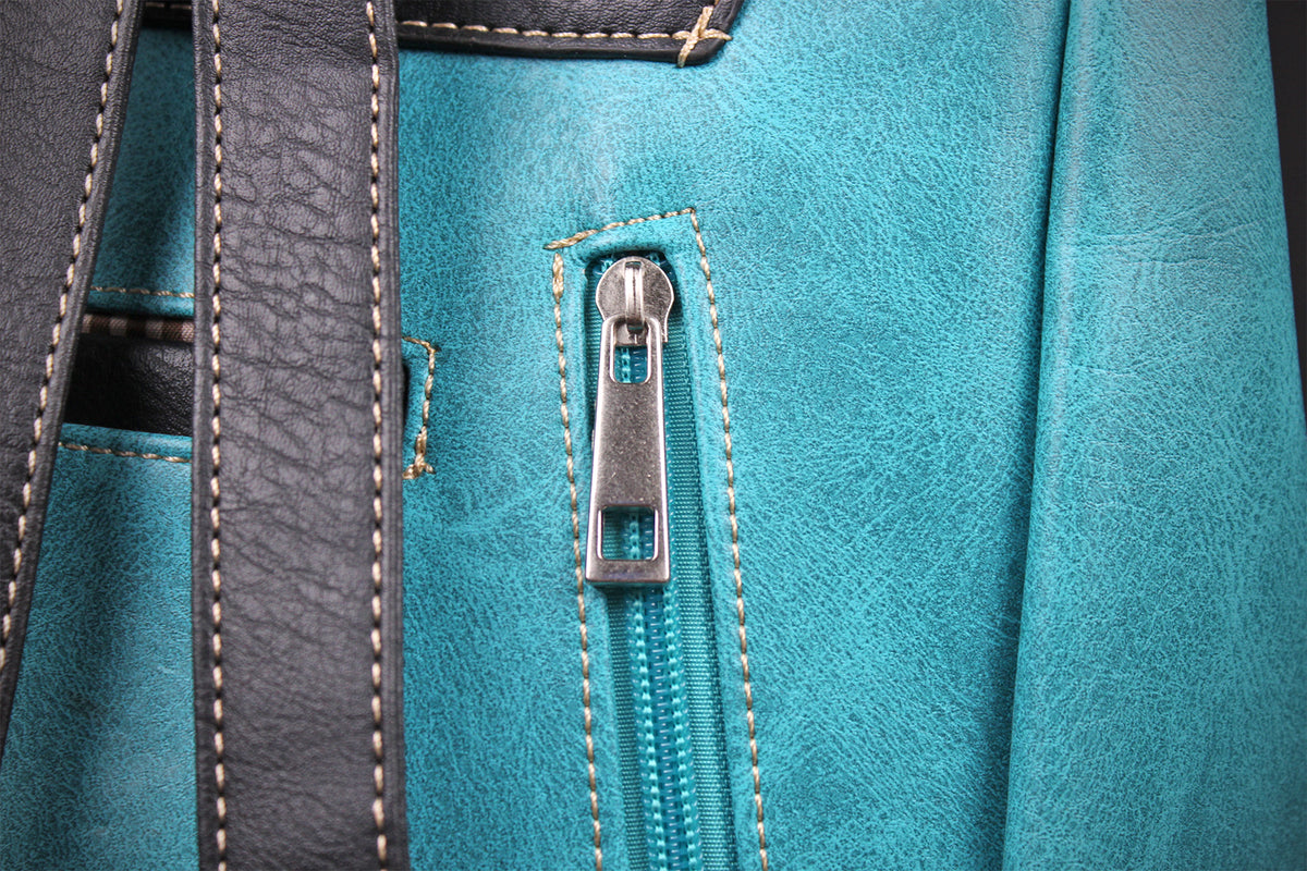 Close-up detail of a turquoise faux-leather bag featuring a silver metal zipper pull, contrast stitching, and dark gray leather straps.