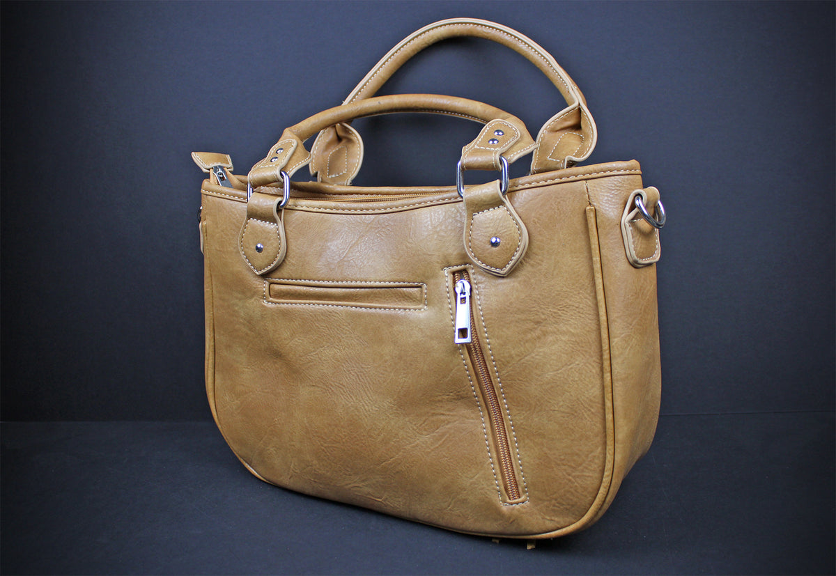 A tan faux-leather handbag with dual top handles, a front zippered pocket, and silver-tone hardware, photographed against a dark gray studio background.