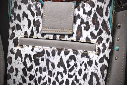 Close-up of a leopard print fabric bag with gray faux-leather trim, a front slip pocket, and a rectangular flap detail.