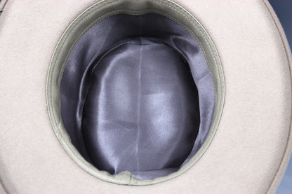 Close-up of the interior of a light beige hat, showing a smooth dark gray satin-like lining and a stitched rim.